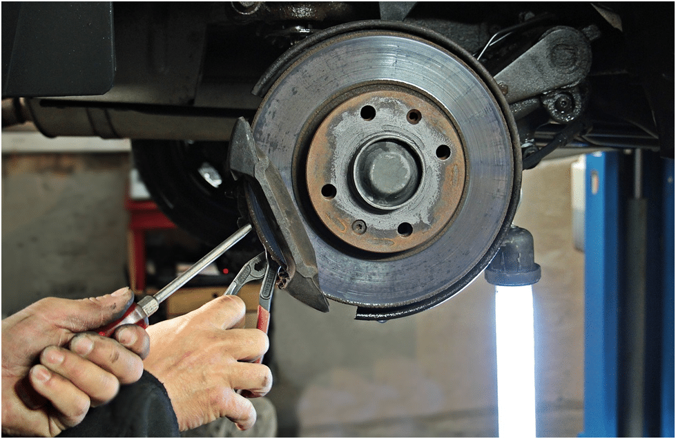 A car mechanic busy fixing brake pads and rotors
