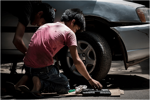 An auto mechanic working on the tires of a car