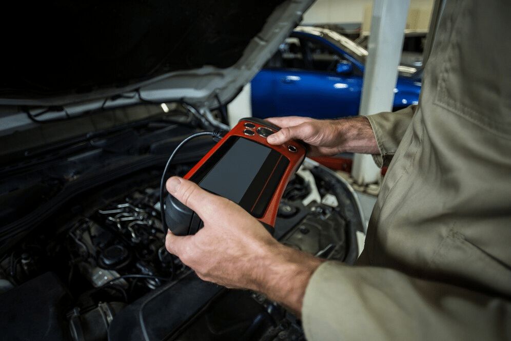 Technician holding advanced diagnostic tool for hybrid vehicles, safety checks Chadds Ford,
family car safety inspection,
comprehensive vehicle checks