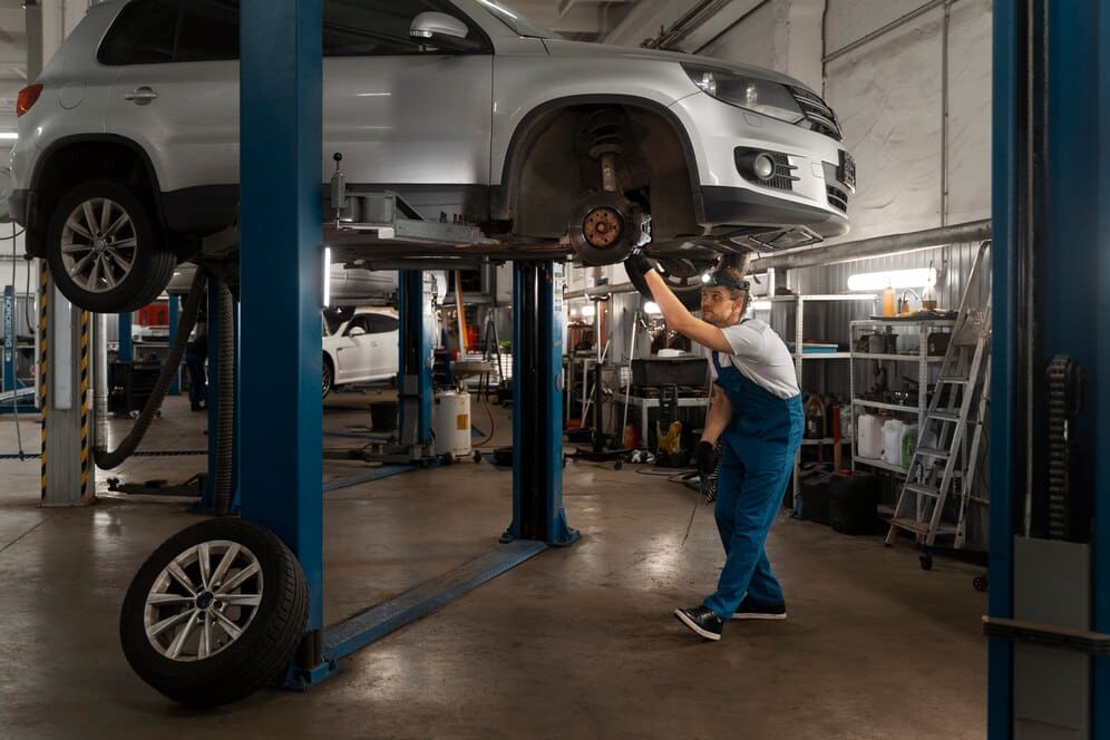 male mechanic working on wheel alignment