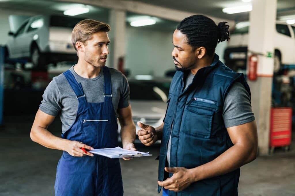 A mechanic discussing an inspection with his colleague