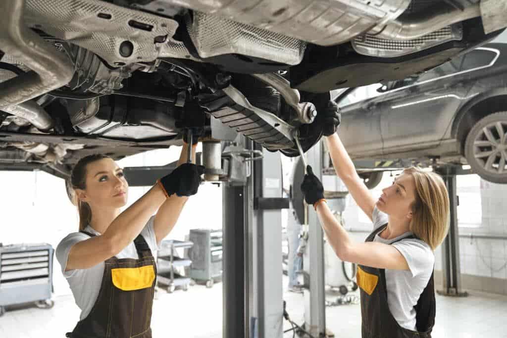 Two technicians working on a car