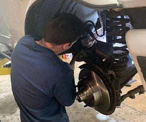 A Welsh Automotive mechanic repairing squeaking brakes