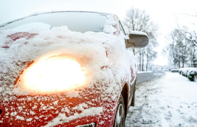 a closesup of a car covered in snow during winter